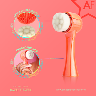 An image of a peach-colored "Cleanse It" 2in1 Exfoliator Brush (2-Pack) from Almost Famous against a pink background. The brush, designed for radiant skin, features extra gentle bristles for thorough cleaning and an ergonomic grip for optimal wrist positioning. Text includes "California Almost Famous" and the website www.almostfamoushair.com.