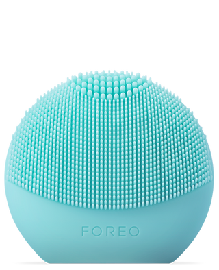 The LUNA "fofo" Smart Facial Cleansing Device by FOREO is a light blue, dome-shaped, silicone device featuring evenly spaced, soft bristles on the top half and "FOREO" embossed on the smooth bottom portion. Sleek and modern in design, it offers personalized cleansing routines for an optimal skincare experience.