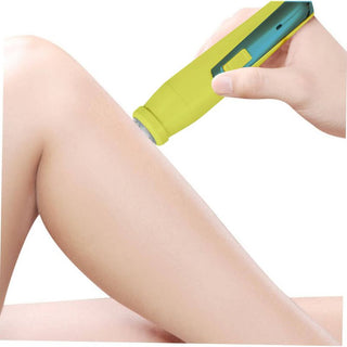 A close-up of a hand using the bliss Portable Body Shaver & Precision Trimmer, a small, green and yellow handheld device, to shave or smooth the skin on someone's slightly bent leg. The background is white.