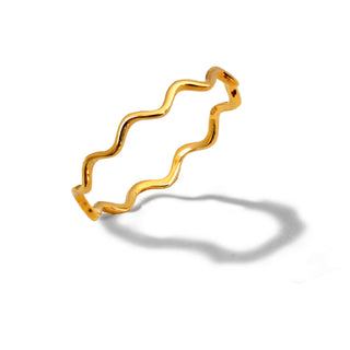 The Noodle Ramen Ring by Sonia Hou Jewelry is depicted against a white background, showcasing its gold band with an irregular, wavy design. The ring's shadow mimics the undulating pattern of the band, creating an intriguing visual effect reminiscent of ramen noodles and subtly nodding to Asian culture and its emphasis on longevity.