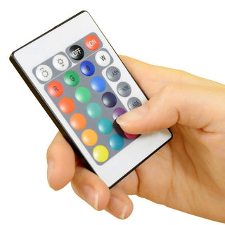 A hand holding a small rectangular remote control with various colorful buttons, including options for red, green, blue, and white lights, on/off settings, and different modes like flash, strobe, and fade—a perfect accessory for your Pool Candy Illuminated LED Color-Changing Chair.