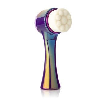 A handheld facial cleansing brush from Almost Famous, named "Cleanse It" 2in1 Exfoliator Brush (2-Pack), featuring a glossy, rainbow-colored handle and a soft white bristle exfoliator brush head. The brush stands upright against a white background, showcasing its sleek and shiny design, ideal for achieving radiant skin and unclogging pores.